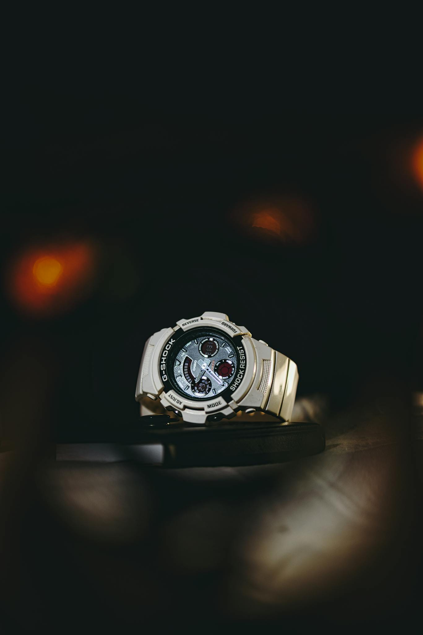 Stylish wristwatch displayed against a dark, moody backdrop, showcasing intricate design.